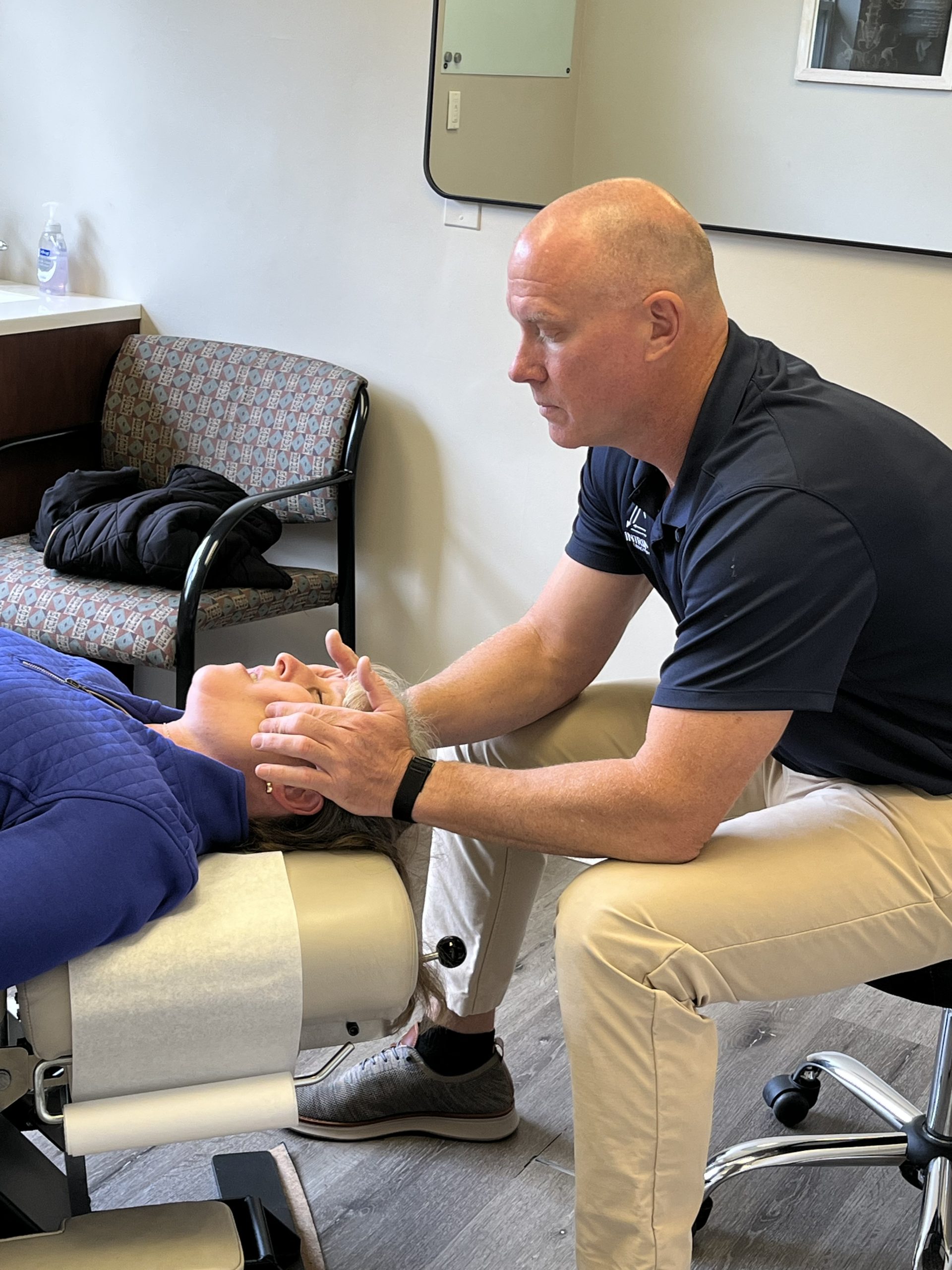 IMG_1140 Chiropractor performing gentle neck adjustment to relieve tension and improve spinal alignment during treatment session